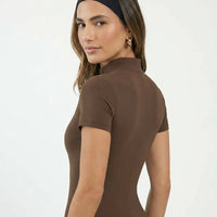 Ghost mannequin back view of black zip-front activewear jumpsuit displaying clean seam lines and ankle-length fit.
