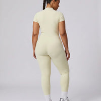 Model facing away in studio showing the back fit of the yellow sculpting activewear jumpsuit.