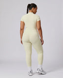 Model facing away in studio showing the back fit of the yellow sculpting activewear jumpsuit.