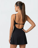 Back view of women's black padel dress with built-in compression shorts on ghost mannequin showing strap detail and clean finish.