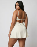 Women's padel dress in creme with square neckline and adjustable straps, ghost mannequin front view.
