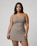 Model wearing grey padel dress with built-in support and flared skirt, front studio view.