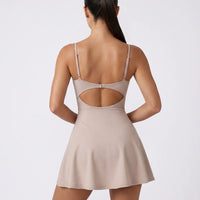 Women's grey padel dress with thin straps and A-line skirt displayed on ghost mannequin, front view.
