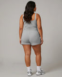 Female model rear studio shot wearing gray sleeveless crop tank showing back fit and strap width.