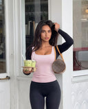 Plus size model back view showcasing the fit of the pink sleeveless tank top across shoulders and torso.