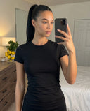 Plus size model back view wearing the black fitted t-shirt top, highlighting smooth fabric lay across shoulders and lower back.
