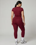 Female model facing away in studio showing the back fit of the red sculpting t-shirt top.