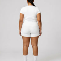 Female model from behind in studio showing the back fit of white ribbed crew neck tee.