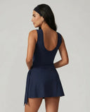 Women's blue active dress with wrap skirt detail displayed on ghost mannequin, back view showing sleeveless design and fitted silhouette.