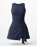 Woman wearing blue active dress with wrap skirt detail in a lifestyle setting, styled for casual athleisure wear.
