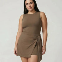 Model wearing brown active dress with wrap skirt detail, front studio view showing fitted silhouette and tie detail at waist.