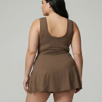 Model wearing brown active dress with wrap skirt detail, back studio view showcasing streamlined fit and minimal design.