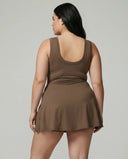 Model wearing brown active dress with wrap skirt detail, back studio view showcasing streamlined fit and minimal design.