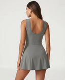 Women's grey active set with sculpting sleeveless top and wrap-tie skirt displayed on ghost mannequin, front view.