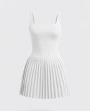 Woman wearing the SEEN Essential white tennis dress in a lifestyle setting, styled for an active day out.
