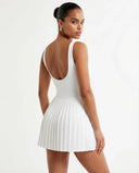 Woman wearing the SEEN Essential white tennis dress in a lifestyle setting, styled for an active day out.