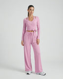 SEEN Essential women's pink yoga set with long-sleeve wrap crop top and wide leg pants displayed on ghost mannequin, front view.