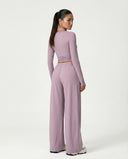 Women's purple yoga set with wrap top and wide leg drawstring pants displayed on ghost mannequin, back view.