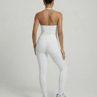 Model wearing a white seamless halter sculpt leggings set with high waist fitted leggings and athletic sneakers.