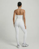 Model wearing a white seamless halter sculpt leggings set with high waist fitted leggings and athletic sneakers.