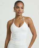 Model wearing a white seamless halter sculpt leggings set with high waist fitted leggings and athletic sneakers.