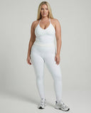 Model wearing a white seamless halter sculpt leggings set with high waist fitted leggings and athletic sneakers.