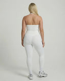 Model wearing a white seamless halter sculpt leggings set with high waist fitted leggings and athletic sneakers.
