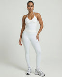 Model wearing a white seamless halter sculpt leggings set with high waist fitted leggings and athletic sneakers.