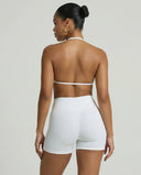Model wearing a white seamless sculpt gym set with high waist shorts and a supportive sports bra paired with athletic sneakers.