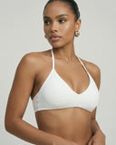 Model wearing a white seamless sculpt gym set with high waist shorts and a supportive sports bra paired with athletic sneakers.