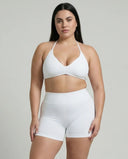 Model wearing a white seamless sculpt gym set with high waist shorts and a supportive sports bra paired with athletic sneakers.