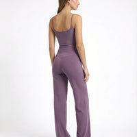 Model wearing mauve high waist crossover wide leg leggings with matching tank top, back view showing V-stitch detail.
