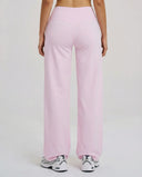 Back view of model wearing pink high waist crossover wide leg leggings, showing V-stitch waistband detail.