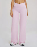 Close-up front view of pink high waist crossover wide leg leggings showing the sculpting V-panel waistband on model.